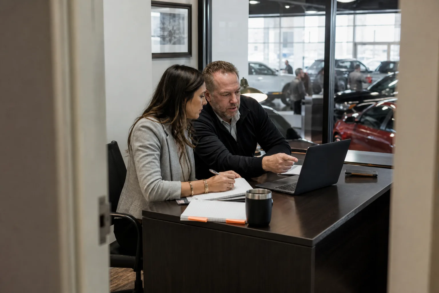 Dealership manager reviewing campaign results with a strategist