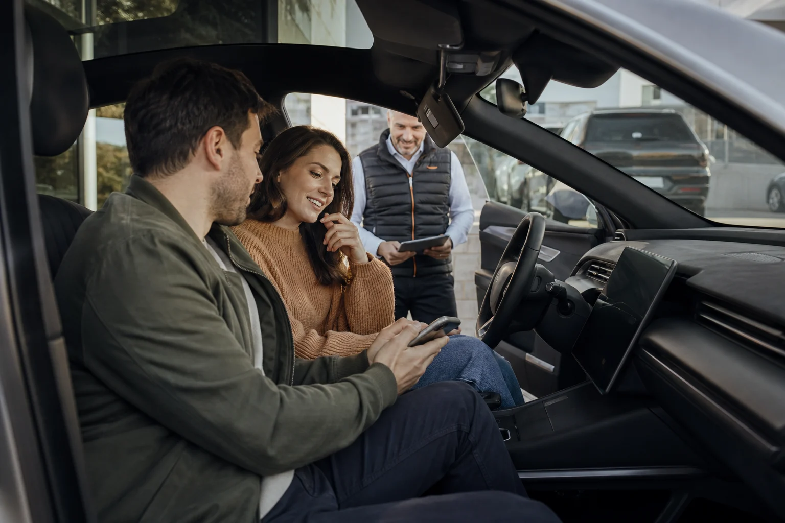 Couple exploring a vehicle with a dealership product specialist